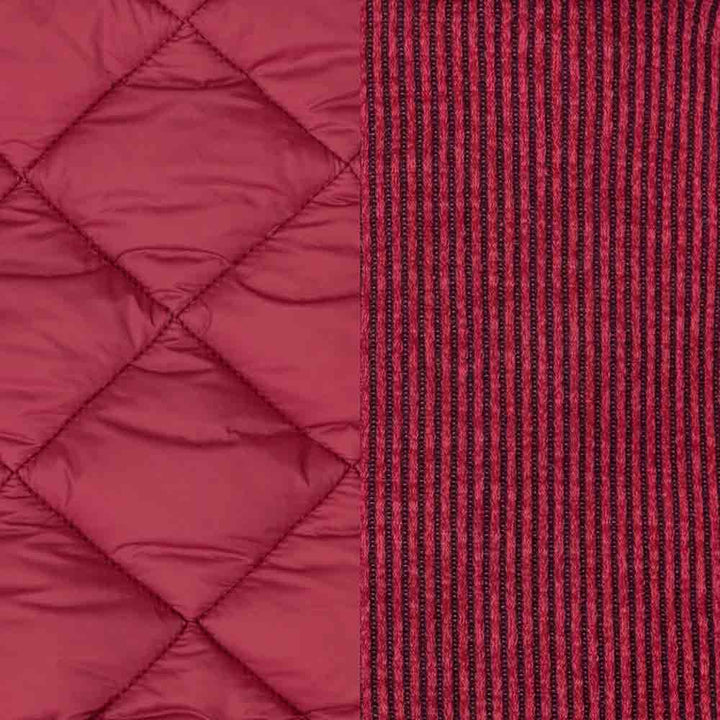 Berry red quilted dog coat with diamond stitching juxtaposed with a black and red striped knit fabric.