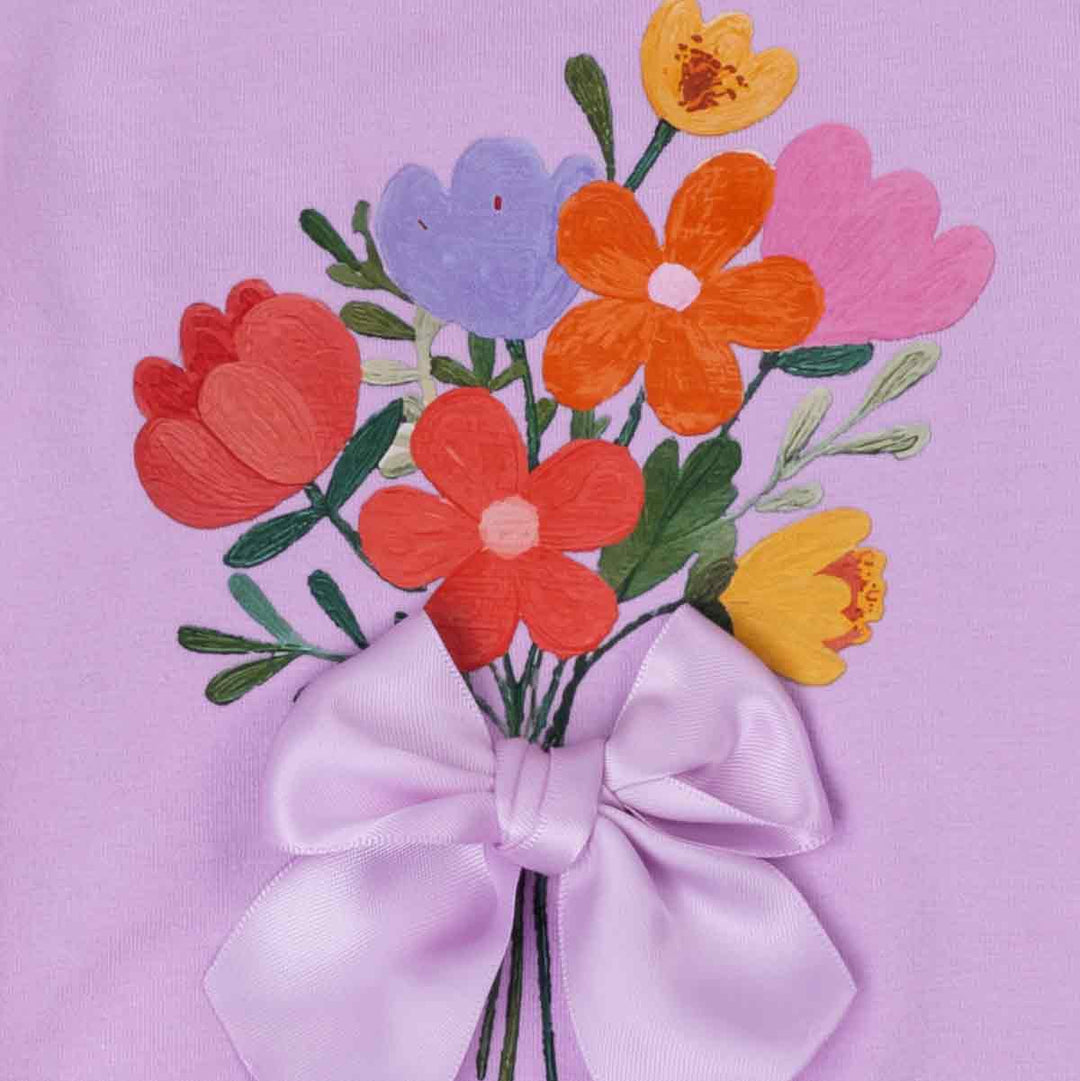 Close up of floral bouquet print and bow detail on purple dog shirt for dogs