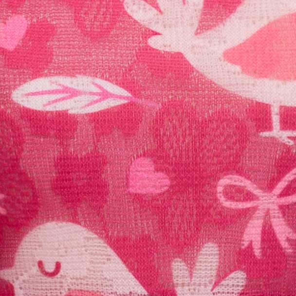 Macro detail of the dog dress’s pink printed lace featuring hearts, bows, and soft woven texture