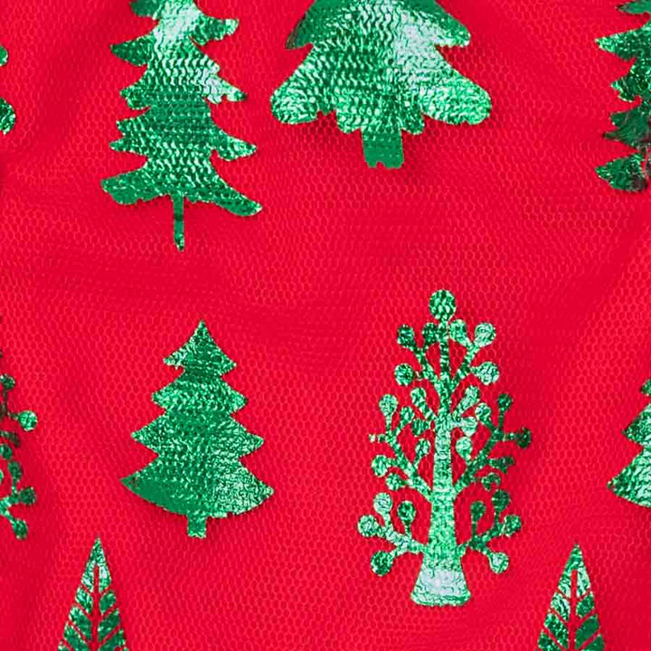 Close-up of red Christmas dog tutu dress fabric with shimmering green tree print texture.