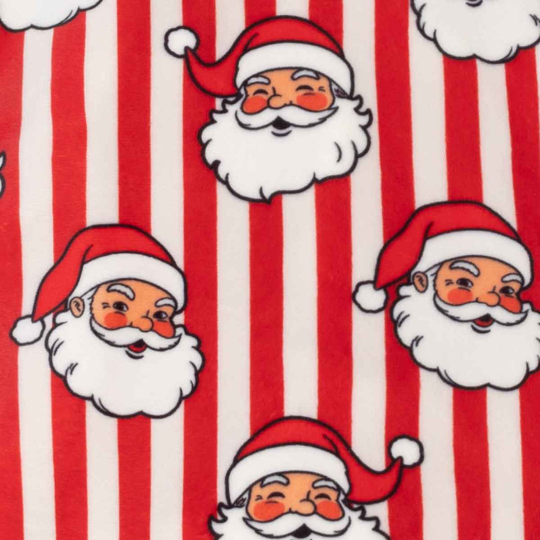 Red and white vertically striped fabric featuring a repeating pattern of cartoon Santa Claus faces with white beards and red hats