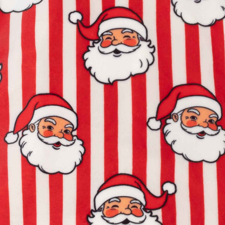 Red and white vertically striped fabric featuring a repeating pattern of cartoon Santa Claus faces with white beards and red hats
