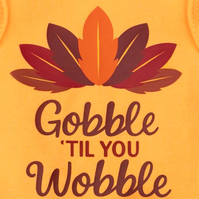 Thanksgiving dog dress close-up with feather print and festive slogan.