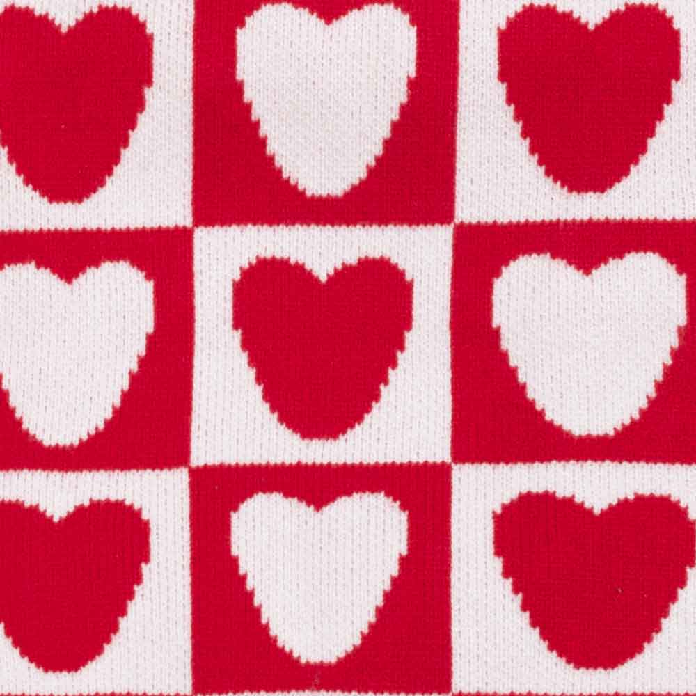 Red and white heart checker pattern detail on knitted dog sweater surface