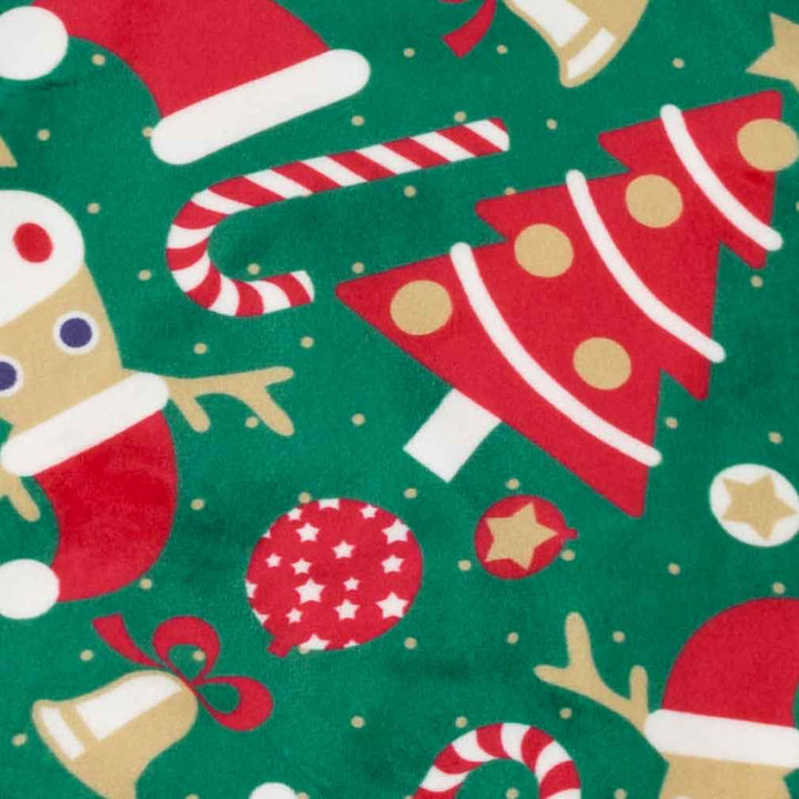 Close-up of a green holiday-themed fabric featuring red Christmas trees, candy canes, ornaments, stars, and gingerbread cookies with white trim
