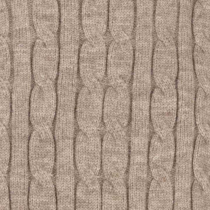 Close-up of a beige cable-knit fabric texture with vertical braided stripes