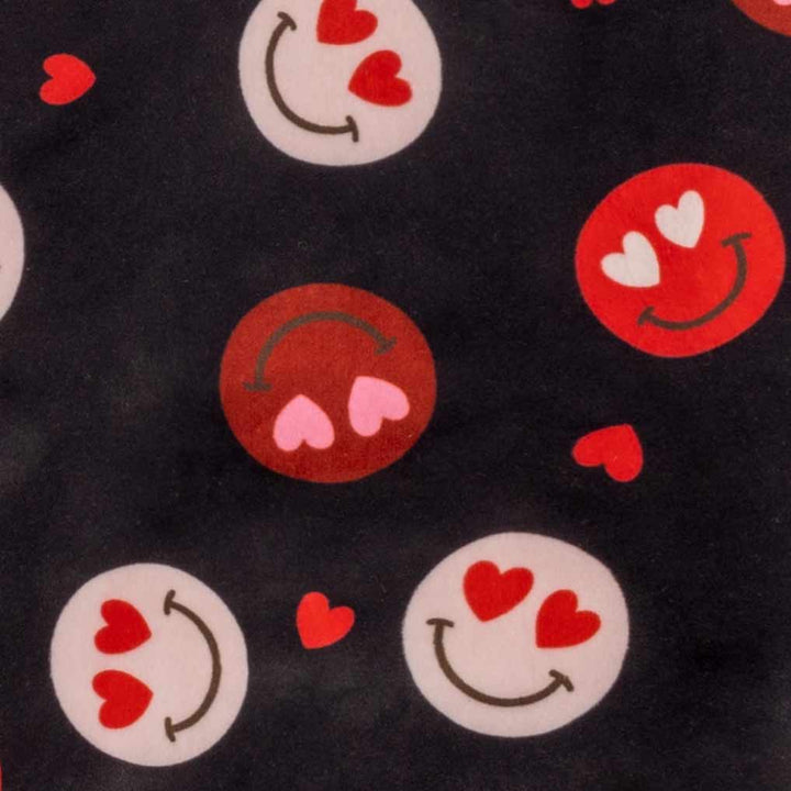 Black dog pajamas with heart-eyes smile emoji pattern, red hearts, and black trim.