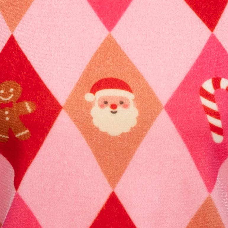 Close-up of a pink and red argyle fabric with a Christmas theme, featuring illustrations of a Santa face, a gingerbread man, and a candy cane