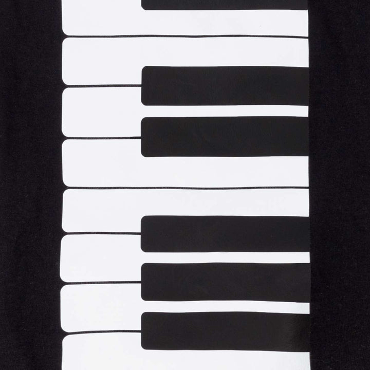 Close-up of a black garment featuring a large white and black piano keyboard graphic printed vertically on the front