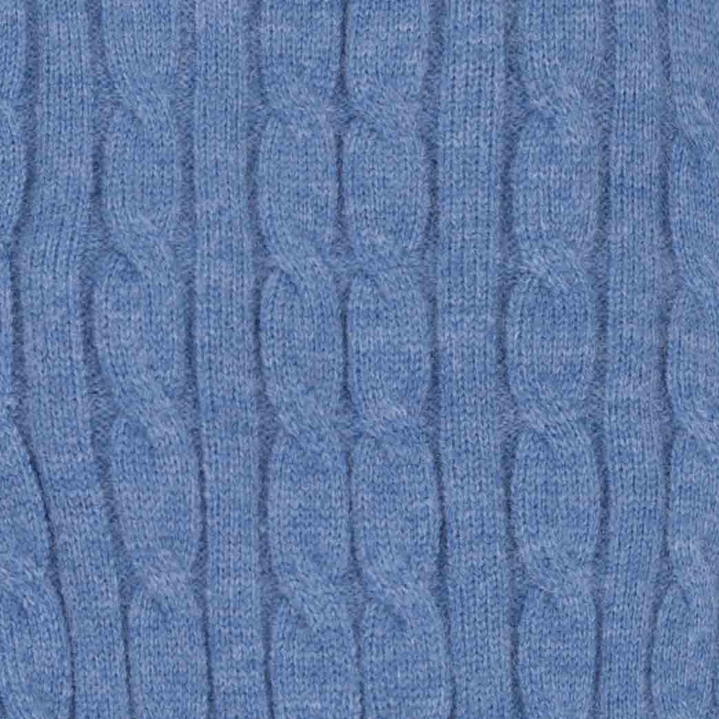Close-up of a blue cable-knit fabric texture, showing the detailed knit pattern and heathered blue color