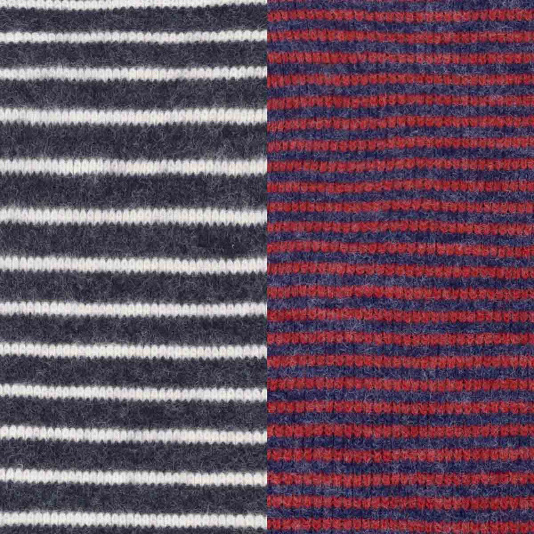 Close-up of a knitted fabric with two vertical color-blocked sections: the left side has dark navy and white horizontal stripes, and the right side has navy and red horizontal stripes