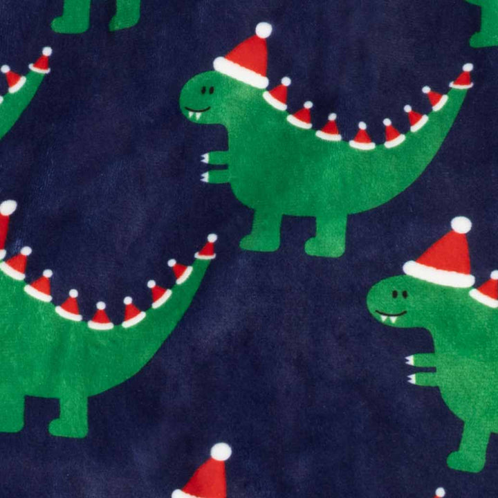 Close up of cozy fabric of dog pjs with dinosaur in Christmas hat