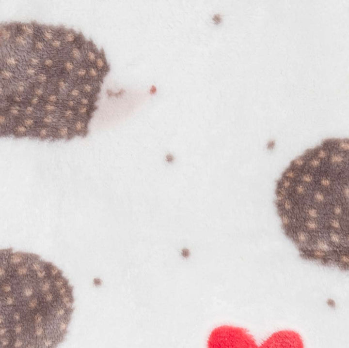 Close-up of a white fabric surface with a hedgehog and heart print