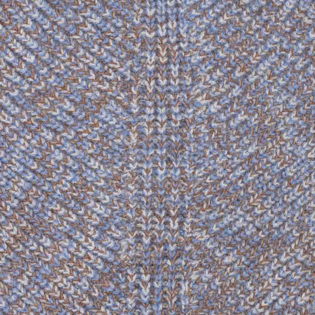 Close-up of a textured knit fabric with a knitted pattern in light blue, beige, and brown