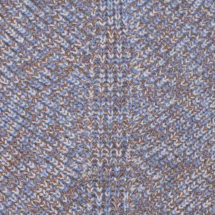 Close-up of a textured knit fabric with a knitted pattern in light blue, beige, and brown