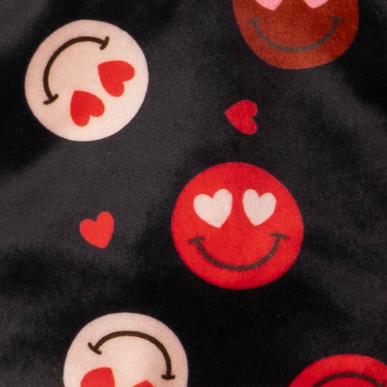 Detailed view of heart-eye smiley print on black dog pajamas.