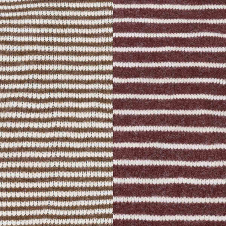 Close-up of a striped knit fabric with alternating sections of brown and burgundy horizontal stripes on a cream background