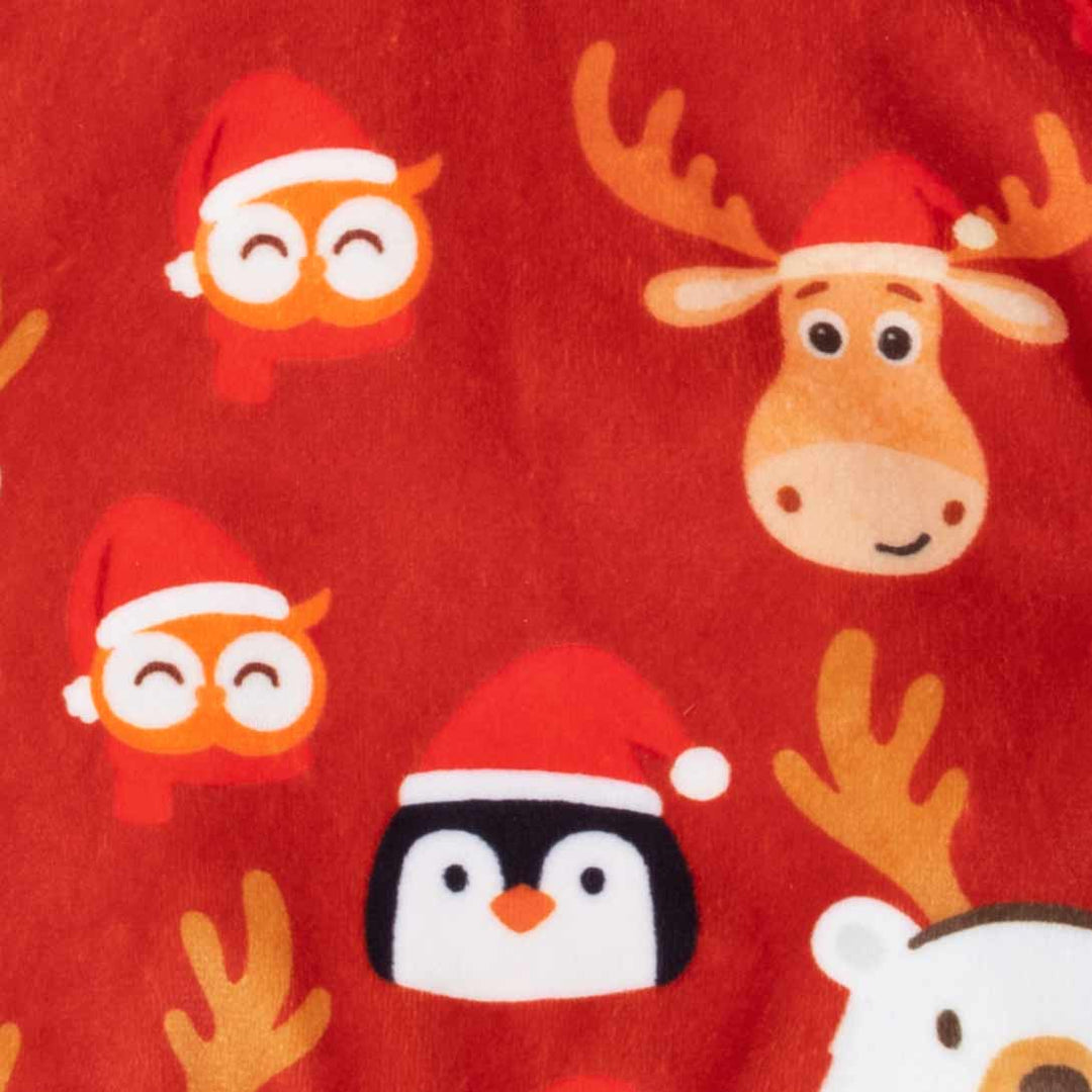 Close-up of red Christmas dog pajamas featuring cartoon owl, penguin, and reindeer prints on soft velvet fabric.