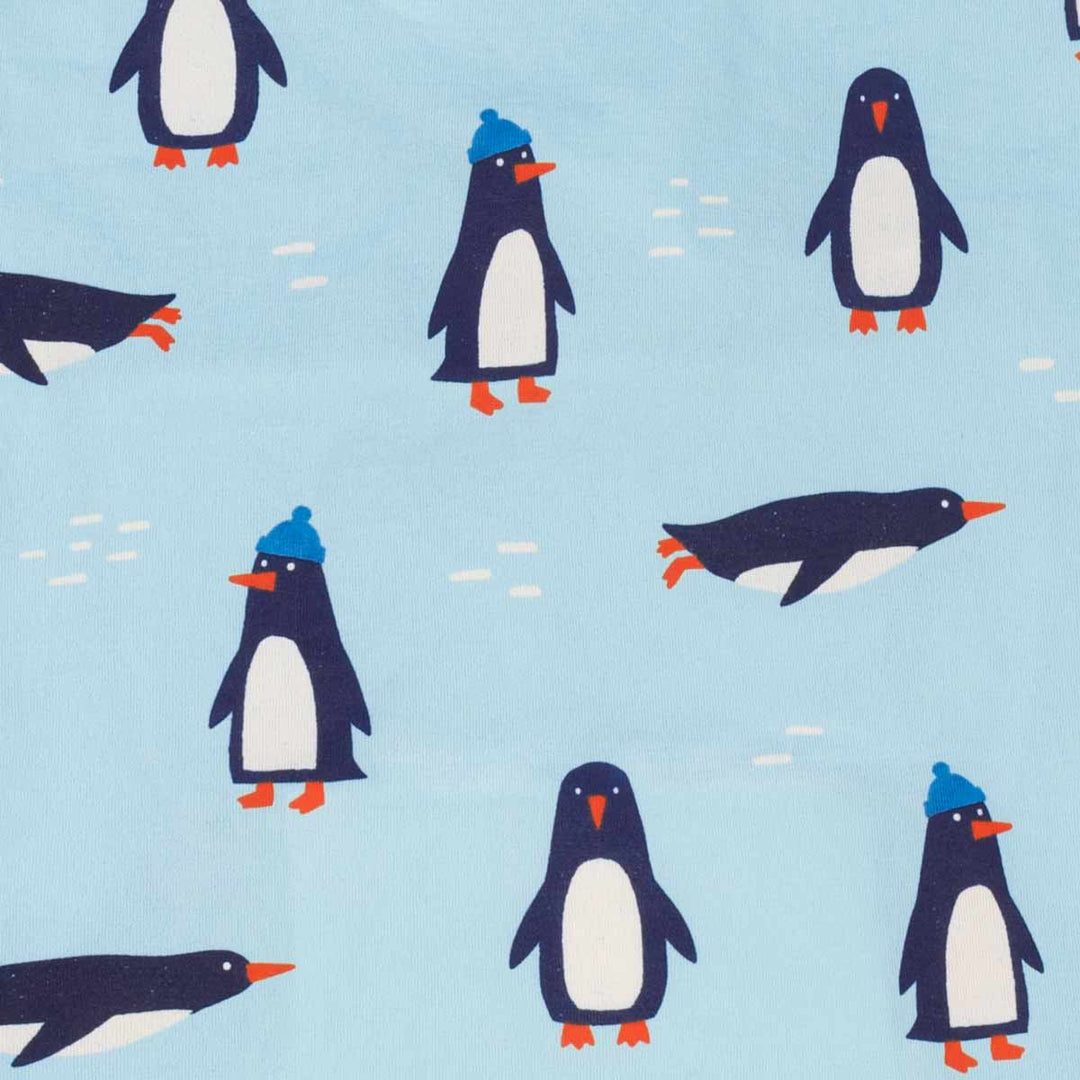 Light blue fabric pattern featuring cartoon penguins in navy, white, and orange, with some wearing blue beanies