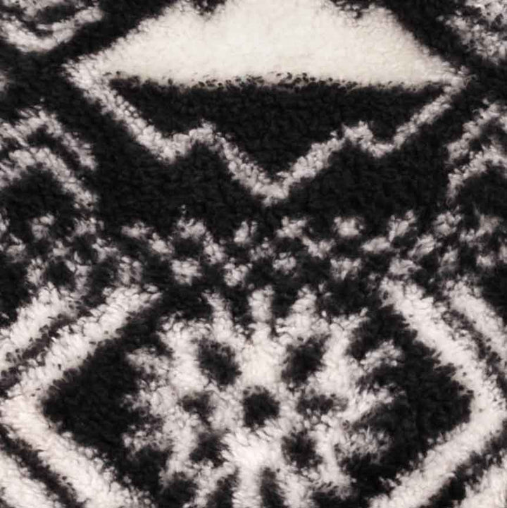 Close-up pattern detail of black and white fleece dog pajamas with geometric winter-inspired design.