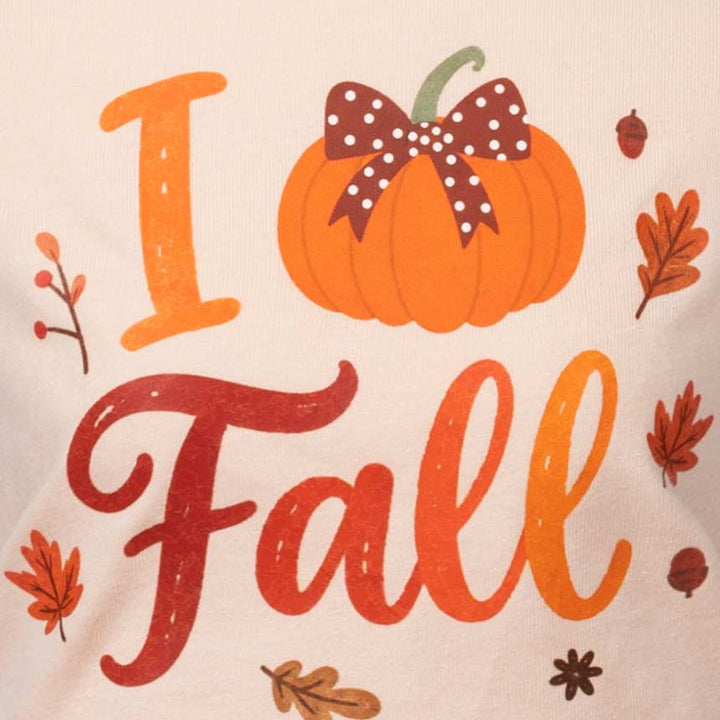 Close-up of a cream-colored fabric featuring a printed autumn graphic that reads 'I Love Fall' with an orange pumpkin, brown polka-dot bow, and scattered fall leaves
