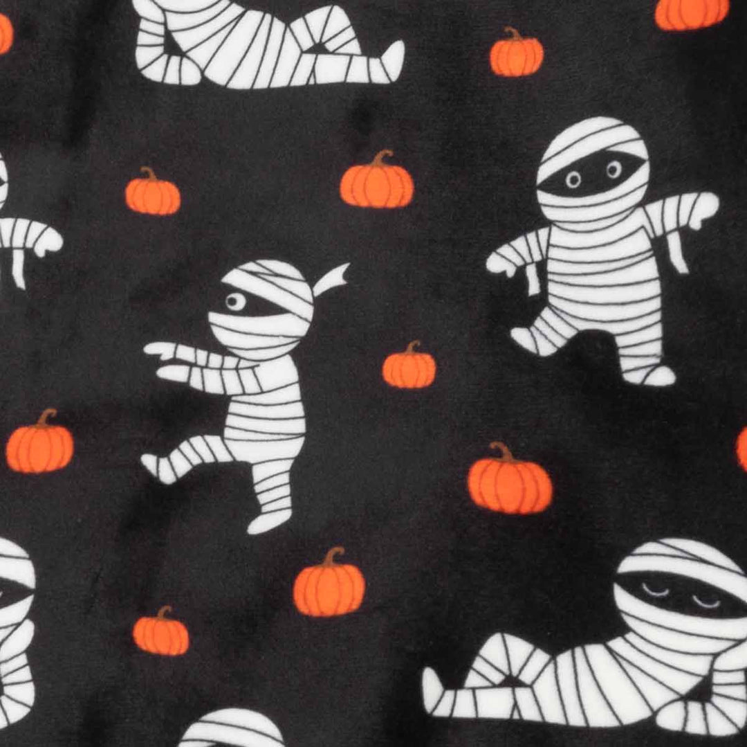 Black fabric with a repeating Halloween pattern of white mummies wrapped in bandages and small orange pumpkins