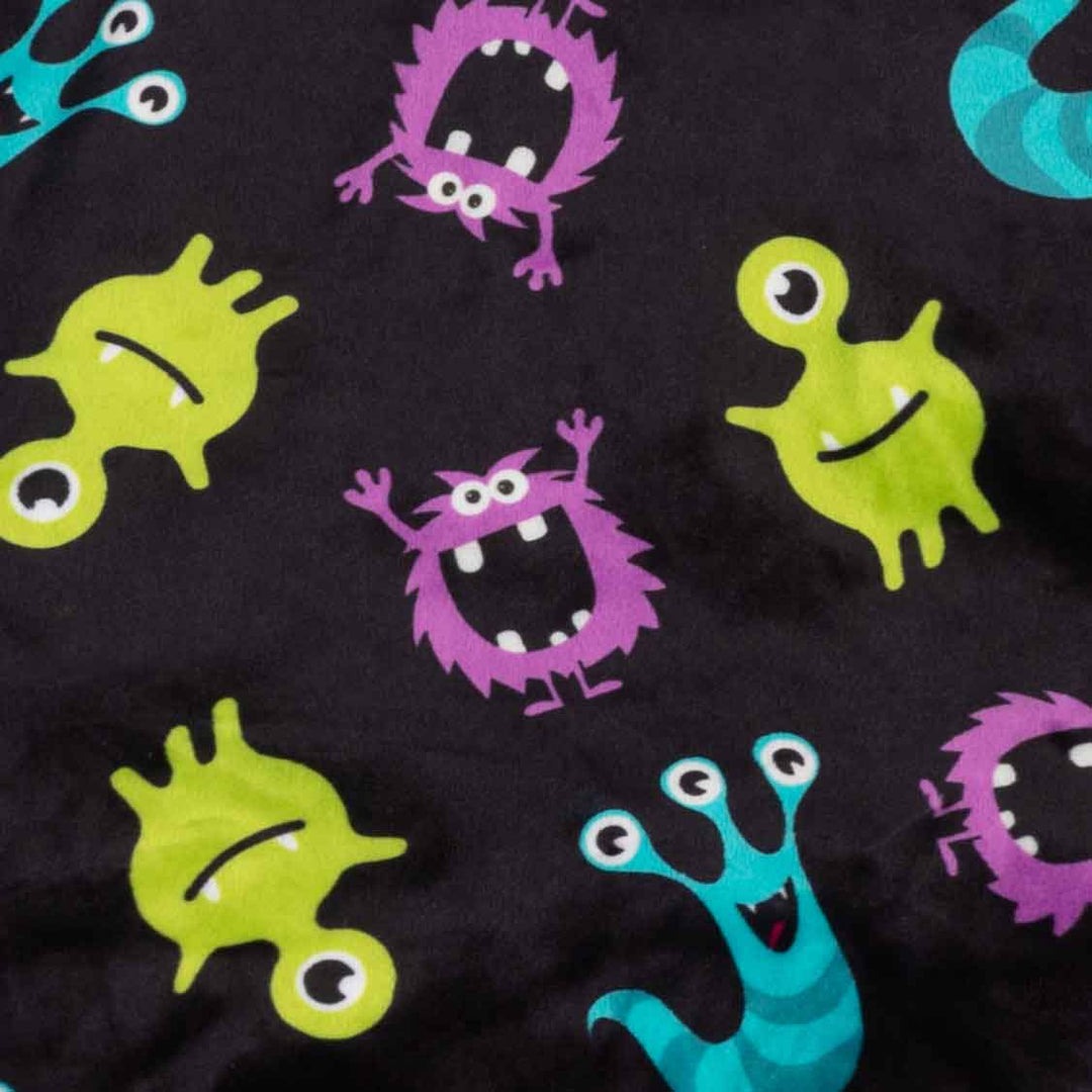 Black dog pajamas with colorful cartoon monsters in purple, green, and teal. Features playful Halloween designs.