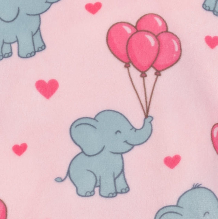 Fabric close up of dog pajamas with cheerful blue elephants and pink heart balloons on a pastel background.