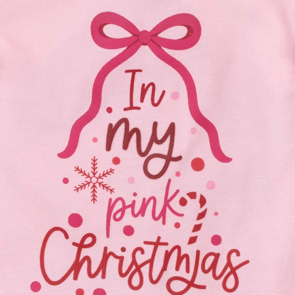 Close-up of a pink garment featuring a graphic design of a Christmas tree shape with a pink bow, the words 'In my pink Christmas Era', red polka dots, and a red snowflake