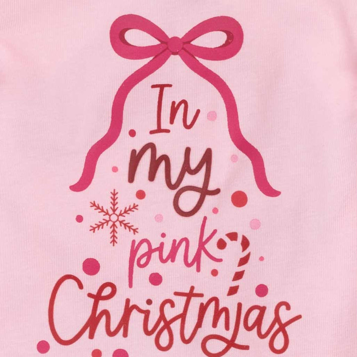 Close-up of a pink garment featuring a graphic design of a Christmas tree shape with a pink bow, the words 'In my pink Christmas Era', red polka dots, and a red snowflake