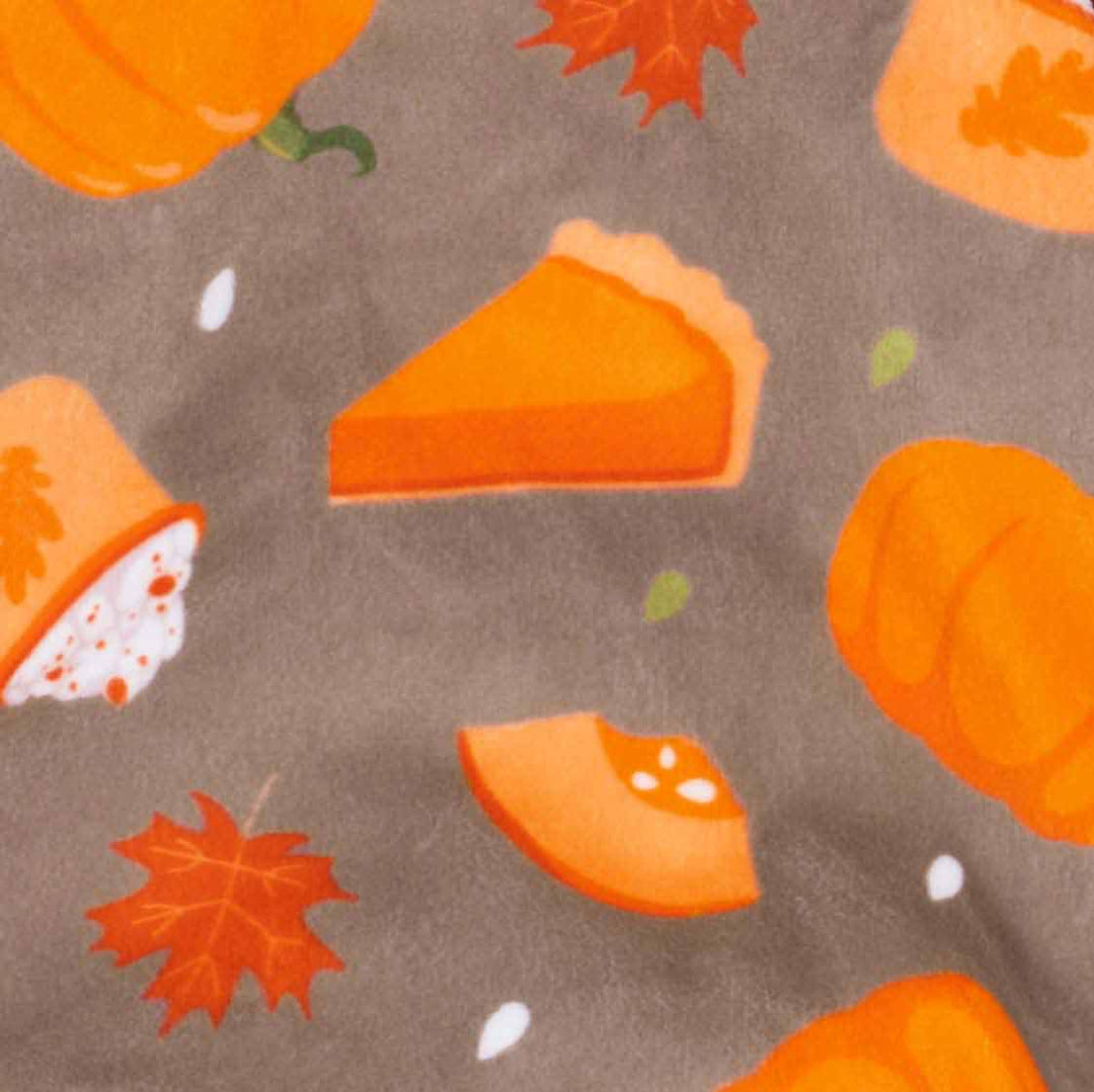 Brown fabric for dog pajamas with festive orange pumpkin, pie, maple leaf, and coffee cup patterns.
