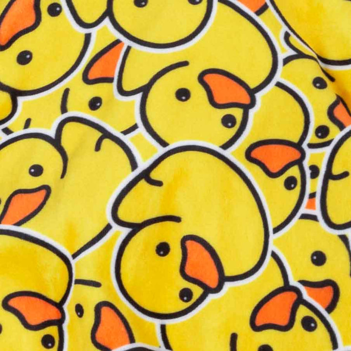 Close up of plush yellow fabric with repeating rubber duck pattern for dog pajamas.