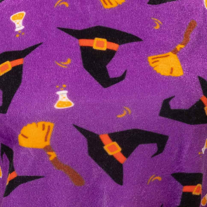 Purple fleece fabric with a repeating Halloween pattern of black witch hats, orange brooms, and potion