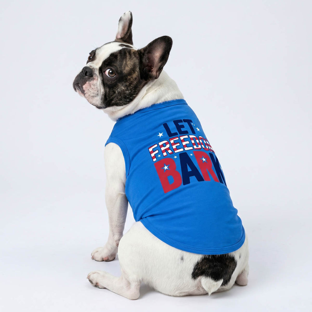 Dog wearing a blue 4th of July shirt for dogs with 'Let Freedom BARK' lettering on a white background
