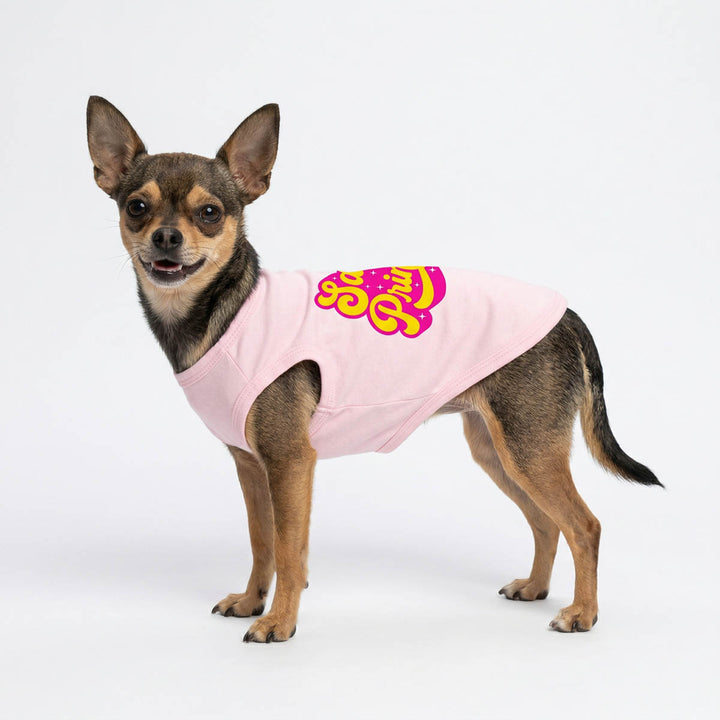 Small dog in a pink dog tank top with pink and yellow text on a white background