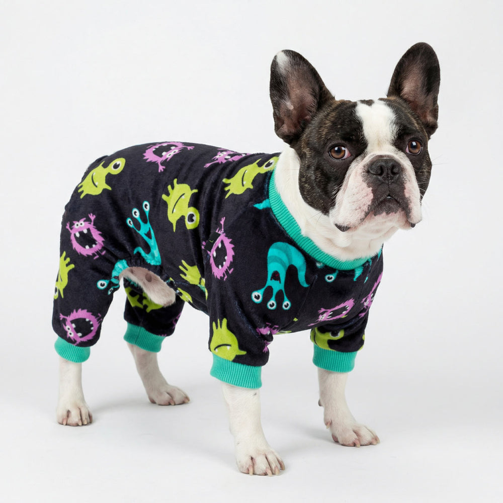 French bulldog wearing black dog pajamas with colorful monster print