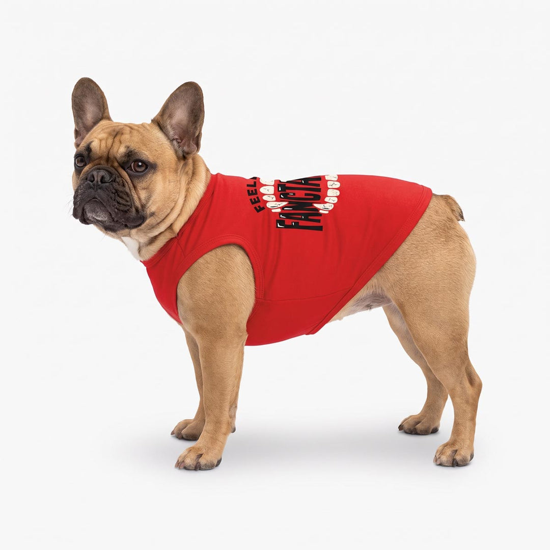 Fawn French Bulldog wearing a red dog tank top with 'Feeling Fangtastic' lettering in black and white on the back, standing against a light gray studio background
